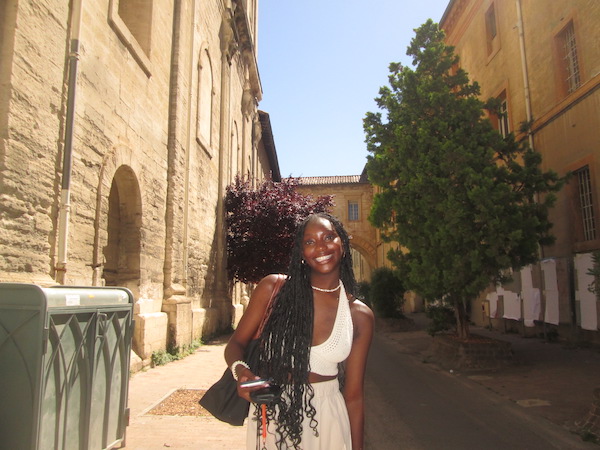 A student in a street full of yellow buildings.