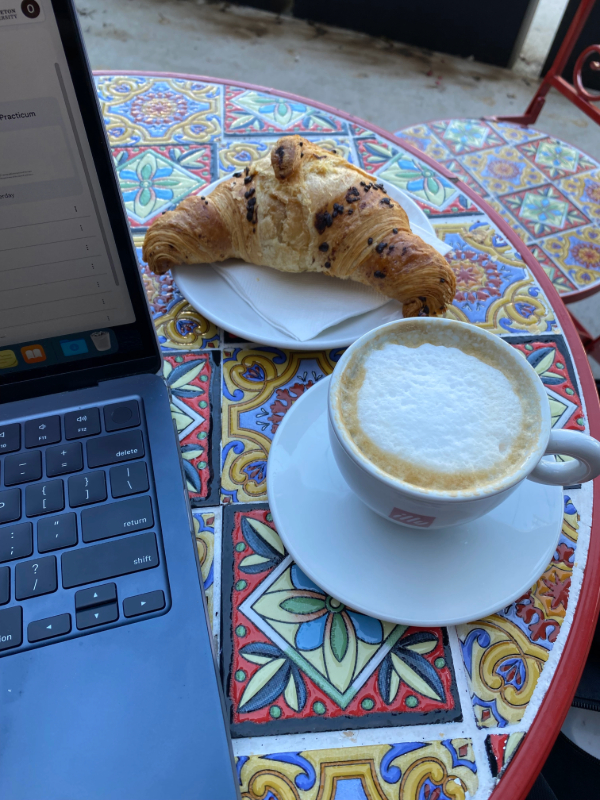 Coffee and croissant on mosaic table.