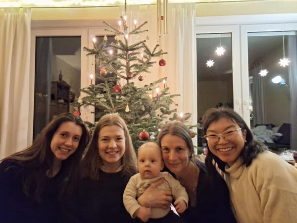 Four women and baby in front a Christmas tree